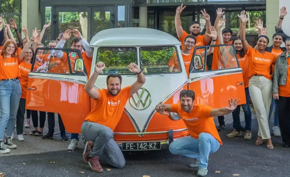 Photo de toute l'équipe de Clementine devant le van Volkswagen orange