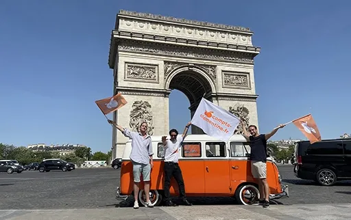 Photo de l'équipe du Clementine Tour et du van devant l'Arc de Triomphe
